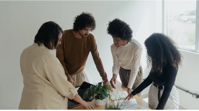 Colleagues gathered around a laptop